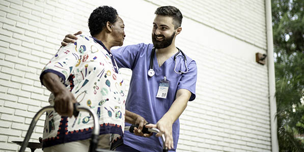 a home health care worker with his patient outside her house